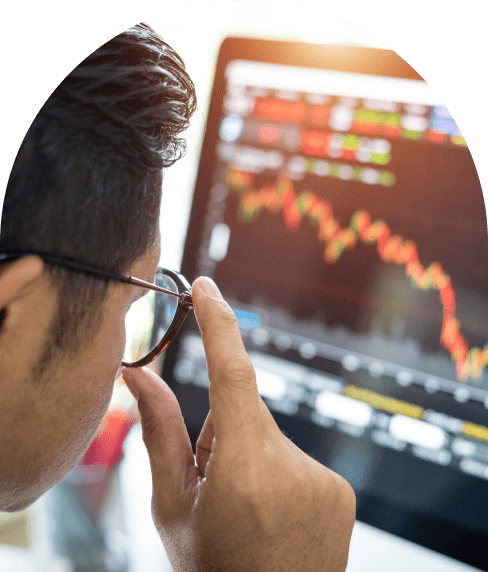Man with glasses looking at computer screen with data bar graphs on it